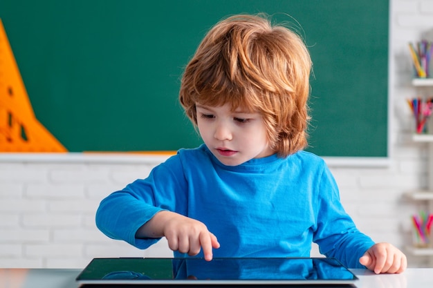 Scolaro con tablet in aula scolastica i bambini imparano i bambini dalla scuola primaria