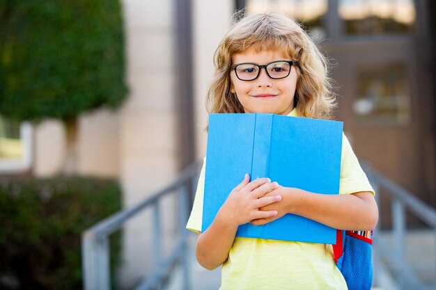 Scolaro emozionante con il libro alla scuola.