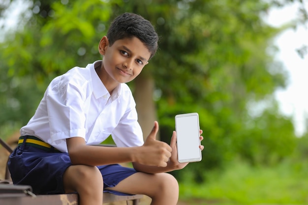 Scolaro indiano che mostra lo schermo dello smartphone concetto di educazione online.