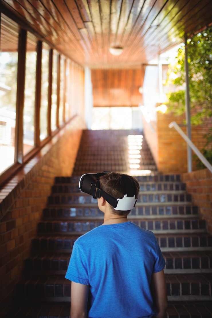 Foto scolaro utilizzando le cuffie da realtà virtuale sulla scala