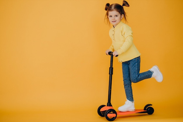 Scooter di guida della bambina in studio