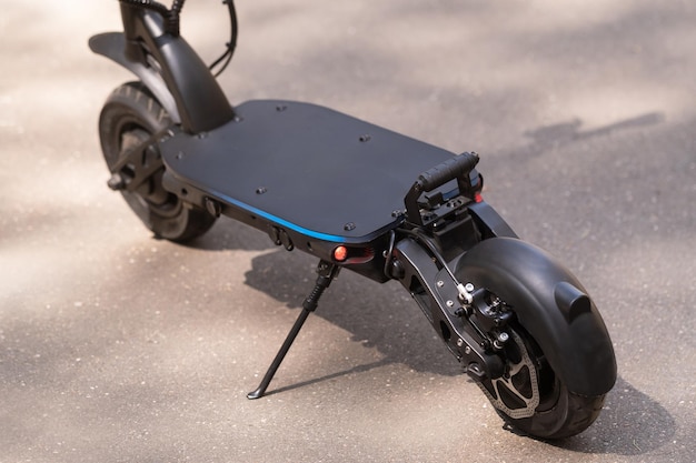 Scooter elettrico nero in piedi sul predellino sulla strada