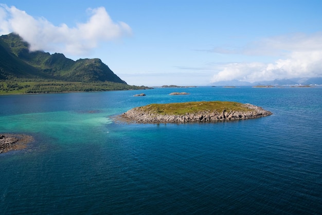 Scopri il mondo. Giro del mondo in crociera. L'isola pietrosa ha circondato l'acqua di mare idilliaca in Norvegia. Vista sul mare con i fiordi norvegesi dell'isola. Costa pietrosa delle scogliere dell'isola. I migliori luoghi naturali da visitare in Norvegia.