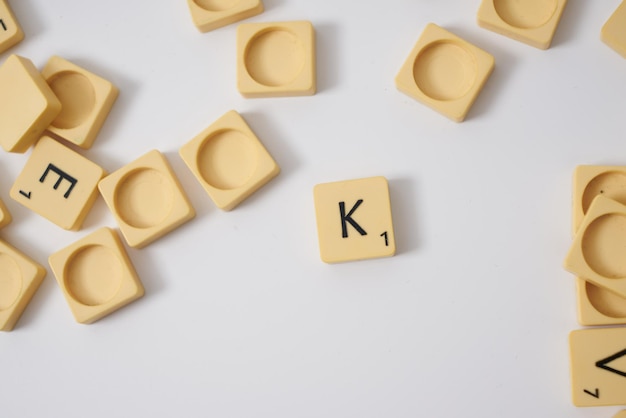 Scrabble lettera K vista dall'alto su sfondo bianco