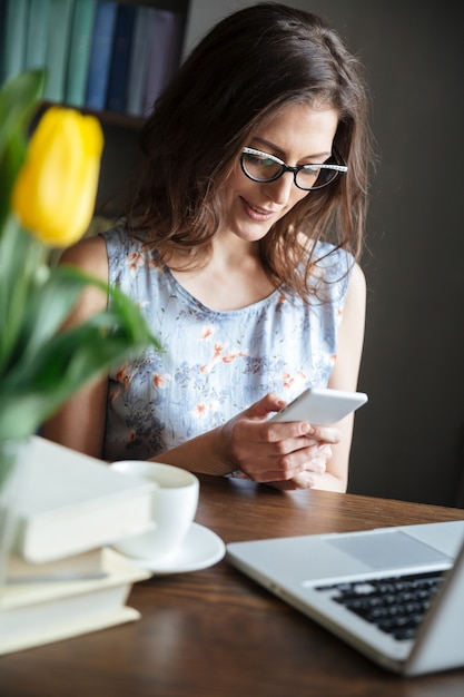 Scrittore grazioso della donna che si siede all'interno mentre chiacchierando per telefono