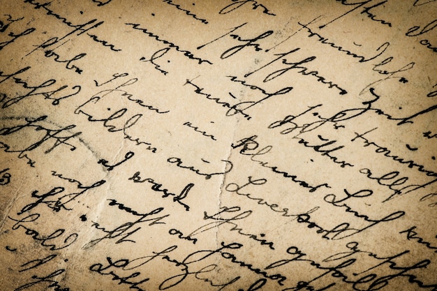 Scrittura a mano d'epoca. scrittura antica. sfondo di carta grunge con vignettatura scura