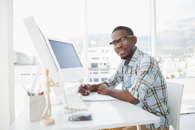 Scrittura casuale sorridente dell&#39;uomo d&#39;affari sulla carta