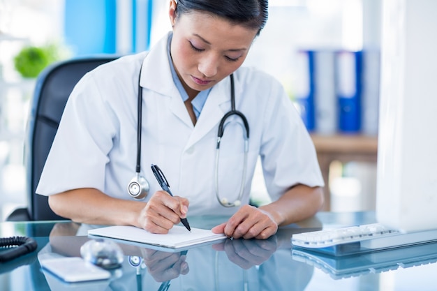 Scrittura concentrata del medico sul taccuino