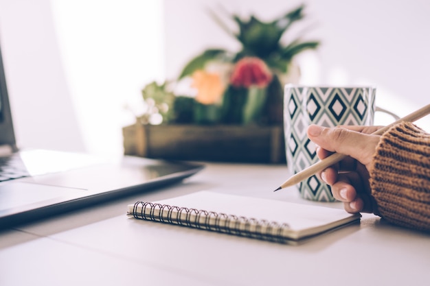 Scrittura della mano della donna in un taccuino