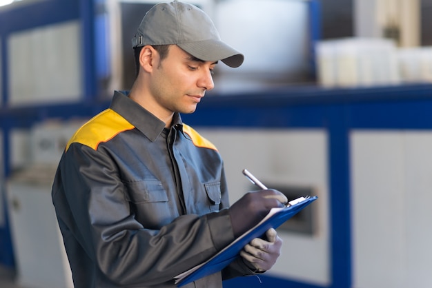 Scrittura Pensive dell&#39;operaio industriale su un documento