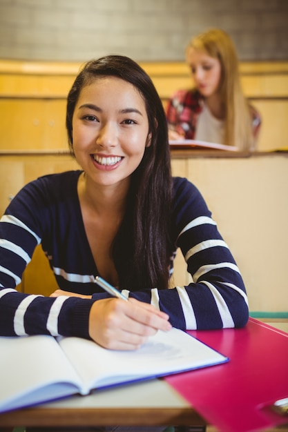 Scrittura sorridente dello studente sul taccuino