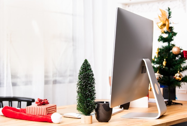 Scrivania da ufficio o luogo di lavoro con computer moderni e decorazioni natalizie.