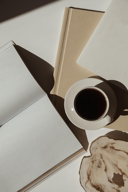 Scrivania per spazio di lavoro minimalista bohémien di lusso estetico Foglio di carta bianco taccuino tazza di caffè album vassoio in pietra di marmo con ombre di luce solare