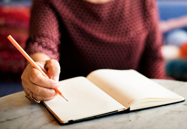 Scrivendo il concetto femminile casuale della matita di svago della nota dell&#39;appunto