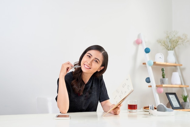 Scrivere studiando il concetto di pianificazione del lavoro. Diario di scrittura della donna asiatica sul taccuino.