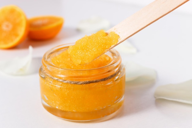 Scrub corpo allo zucchero con arance succose mature su un tavolo di legno bianco
