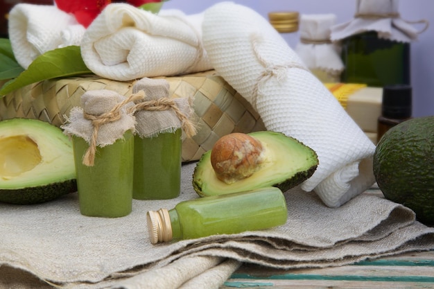 Scrub corpo con olio di avocado. Prodotti termali in background.