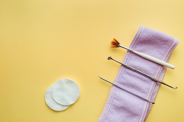 Scrubber ad ultrasuoni, pennello cosmetico per peeling uno cucchiaio giace su uno sfondo giallo