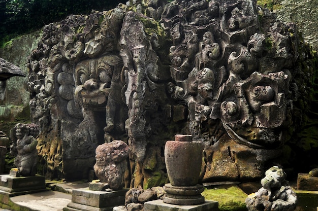 Scultura antica scultura cancello d'ingresso tunnel di Goa Gajah o Grotta dell'Elefante significativo sito archeologico indù per i viaggiatori che le persone viaggiano visitano e rispettano pregando nella città di Ubud a Bali Indonesia