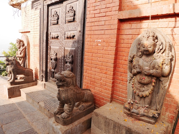 Scultura divinità custode e scultura in pietra di leone figura presso antiche rovine edificio antico della pagoda Swayambhunath Tempio delle scimmie per nepalesi e viaggiatori stranieri visita a Kathmandu Nepal