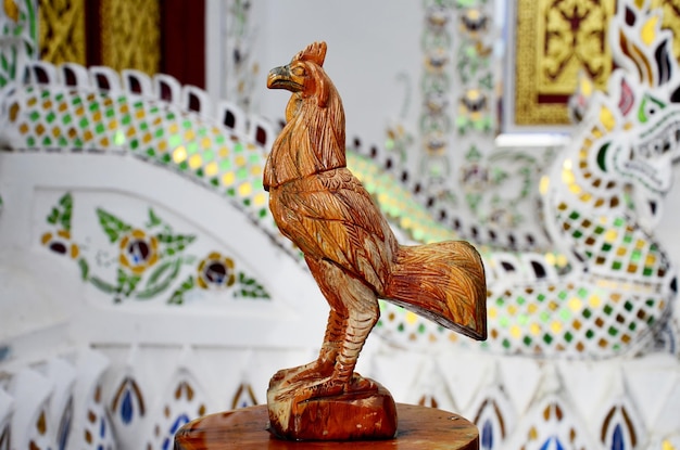 Scultura in legno in stile tailandese tradizionale come gallo di legno animale uno dei 12 zodiaci nella chiesa del tempio in Thailandia e questa arte decorata è stata creata con denaro donato da persone senza limitazioni nella copia o nell'uso