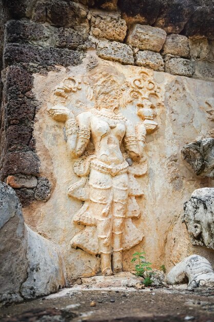 Scultura in pietra su muro di mattoni