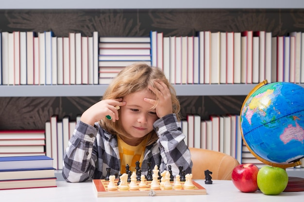 Scuola di scacchi per bambini bambino intelligente che pensa agli scacchi ritratto di bambino intelligente con scacchiera ragazzo p