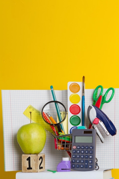 Scuola e forniture per ufficio su sfondo giallo torna a scuola