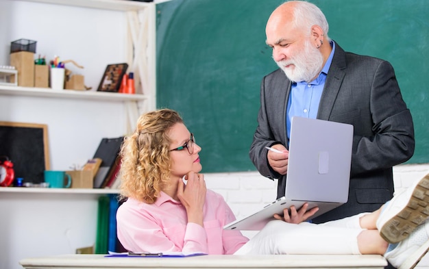 Scuola moderna Insegnare lezioni private in modo eccellente condividere la conoscenza Uomo insegnante di scuola matura e studentessa spensierata con laptop Liceo college Università Comunicare in modo chiaro ed efficace