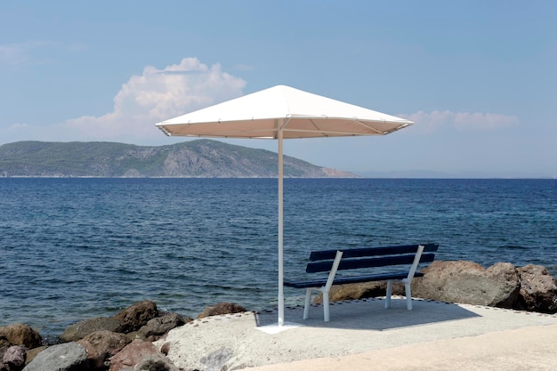 Seascape Le panchine e gli ombrelloni sulla spiaggia sullo sfondo del mare e delle montagne