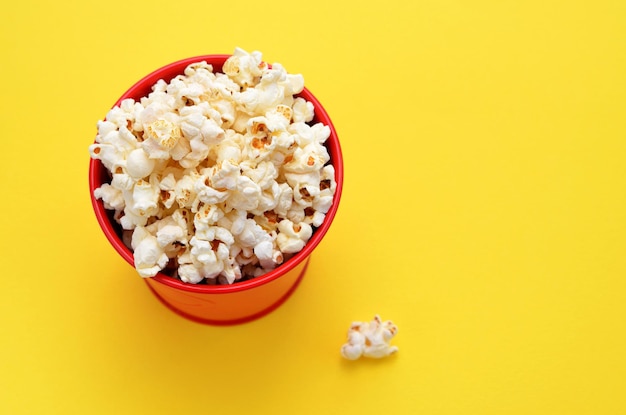 Secchio con popcorn su sfondo giallo primo piano