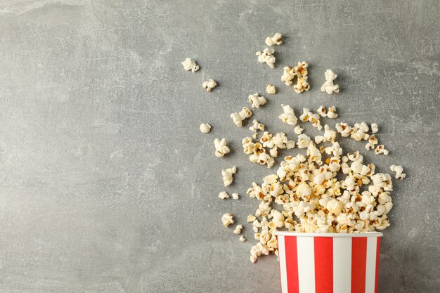 secchio e popcorn su sfondo grigio