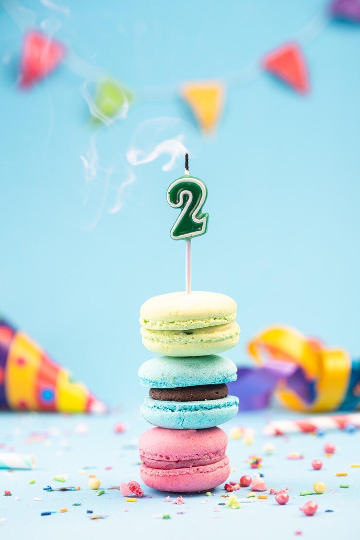 Secondo biglietto di compleanno con candela spenta in amaretti colorati e mockup di carta spruzzata