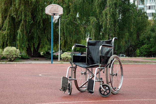 Sedia a rotelle sul campo da basket. Riabilitazione, parkinson, disabile, paralizzato.