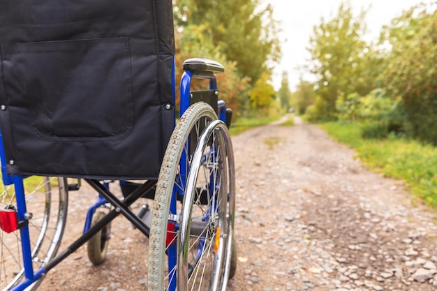 Sedia a rotelle vuota in piedi sulla strada in attesa di servizi per i pazienti Sedia a rotelle per persone con di...