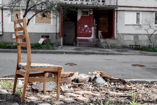 Sedia abbandonata vicino a un edificio residenziale distrutto