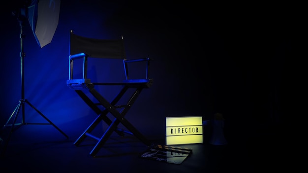 Sedia da regista con segno lightbox cinematografico Testo del regista su di essa e megafono clapperboard