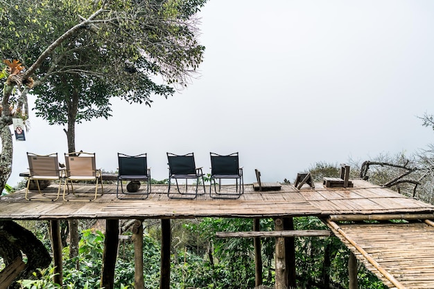 Sedia sul balcone con collina di montagna e sfondo nebbioso