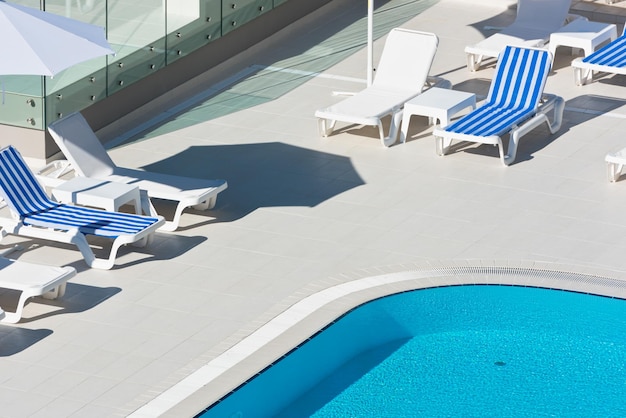 Sedie a bordo piscina dell'hotel vicino a una piscina. Scatto estivo