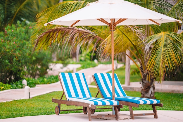 Sedie a sdraio bianche su una bellissima spiaggia tropicale