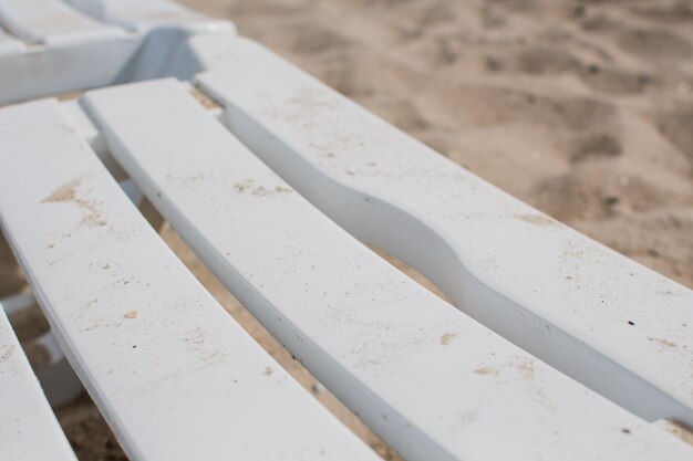 Sedie a sdraio bianche sulla spiaggia di sabbia