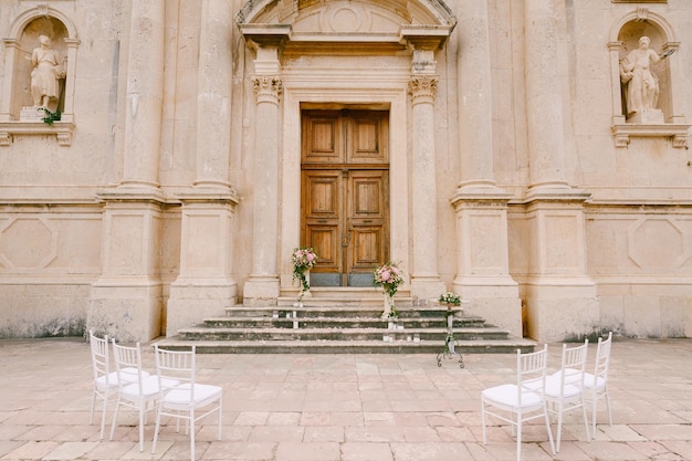 Sedie bianche stanno davanti all'ingresso della chiesa della natività della vergine a prcanj