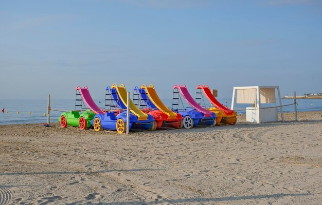 Sedie da spiaggia di plastica colorate su una spiaggia sabbiosa di Alicante, in Spagna