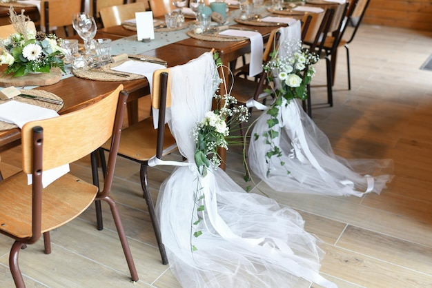 Sedie da sposa decorate con tulle bianco e fiori