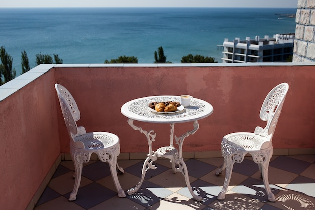 Sedie e un tavolo sono sulla veranda con splendida vista sul mare