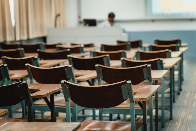 Sedie in legno disposte in aula. Aula universitaria vuota con molte sedie in legno ma senza studenti. Torna al concetto di scuola.