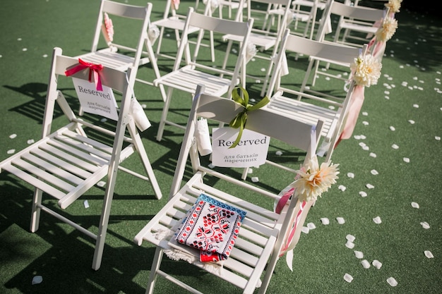 Sedie per una cerimonia di matrimonio con decorazioni nel parco