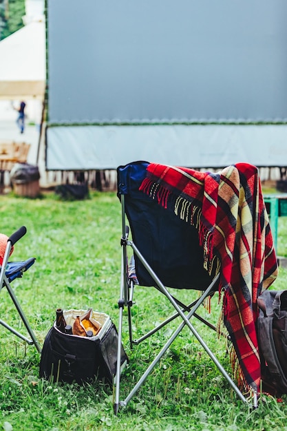 Sedie pieghevoli con concetto di cinema all'aperto davanti al grande schermo bianco