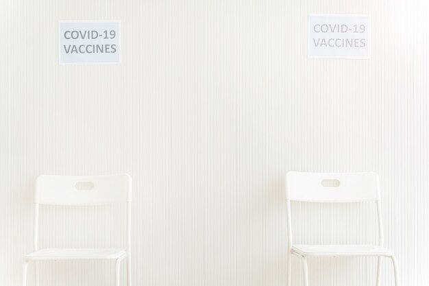 Sedie posizionate nella stazione di attesa per ottenere il vaccino contro il covid in clinica o in ospedale con muro bianco