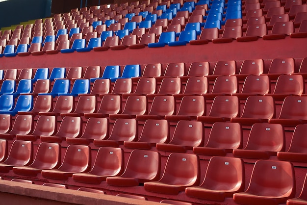 sedie rosse della carta da parati della fila del sedile dello stadio vuote
